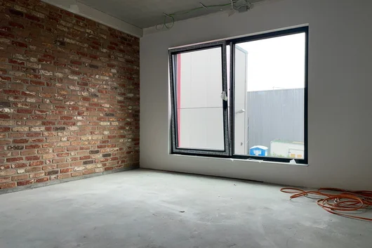 Büroraum im Ausbau bei K60 in Langenberg mit Sichtziegelwand und großem zweiteiligem Fenster