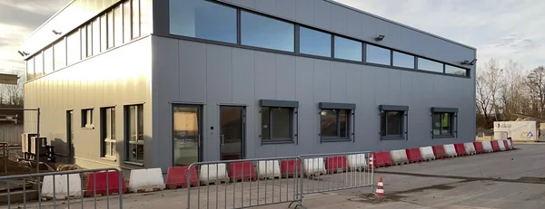 Moderne Werkstatthalle mit Verwaltung in Bad Salzuflen Neubau einer Werkstatthalle mit Verwaltungsgebäude in Bad Salzuflen, moderne Industriearchitektur mit Fassadenverkleidung und Fensterband.