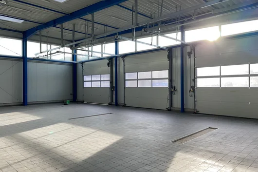 Innenansicht Werkstatthalle mit Sektionaltoren Innenraum einer neu gebauten Werkstatthalle in Bad Salzuflen mit großen Sektionaltoren, Stahlkonstruktion und gefliestem Hallenboden für Werkstattnutzung.