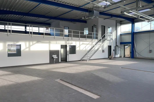 Werkstatthalle mit integrierter Verwaltungsebene und Treppenaufgang Innenansicht einer Werkstatthalle in Bad Salzuflen mit integrierter Büroebene, Treppenanlage, Stahlkonstruktion und großflächigem Werkstattboden.