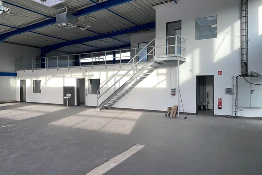 Werkstatthalle mit integrierter Verwaltungsebene und Treppenaufgang Innenansicht einer Werkstatthalle in Bad Salzuflen mit integrierter Büroebene, Treppenanlage, Stahlkonstruktion und großflächigem Werkstattboden.