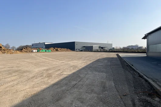 Neubau eines Speditionsbetriebes in Hüllhorst mit entstehendem Hallengebäude und vorbereiteter Hof- und Logistikfläche im Vordergrund
